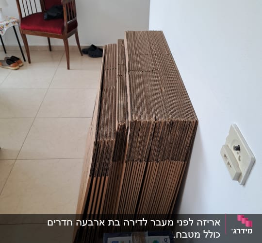ערימת קרטונים מקופלים ליד קופסת מדפסת